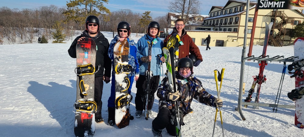5 students posing with ski equipment at Chestnut Mountain