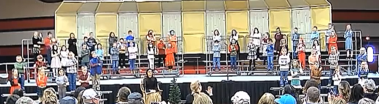 Image of students on stage singing.