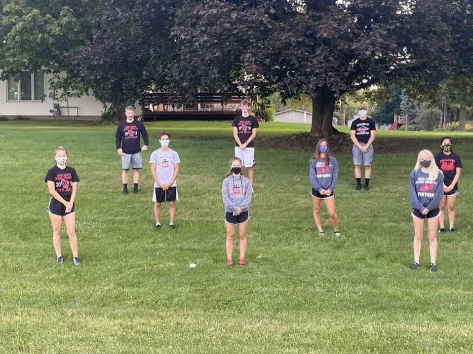 Photo of students at run club in Summer 2020.  Students are standing with their masks on outdoors.