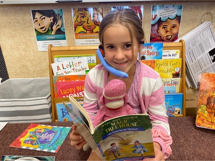 Student reading a book to her pet.